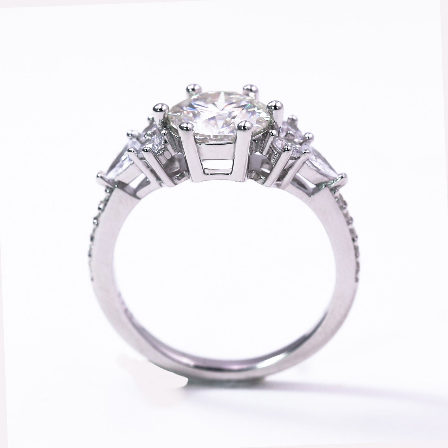 Diamond ring with a central gemstone and three smaller stones on a white background
