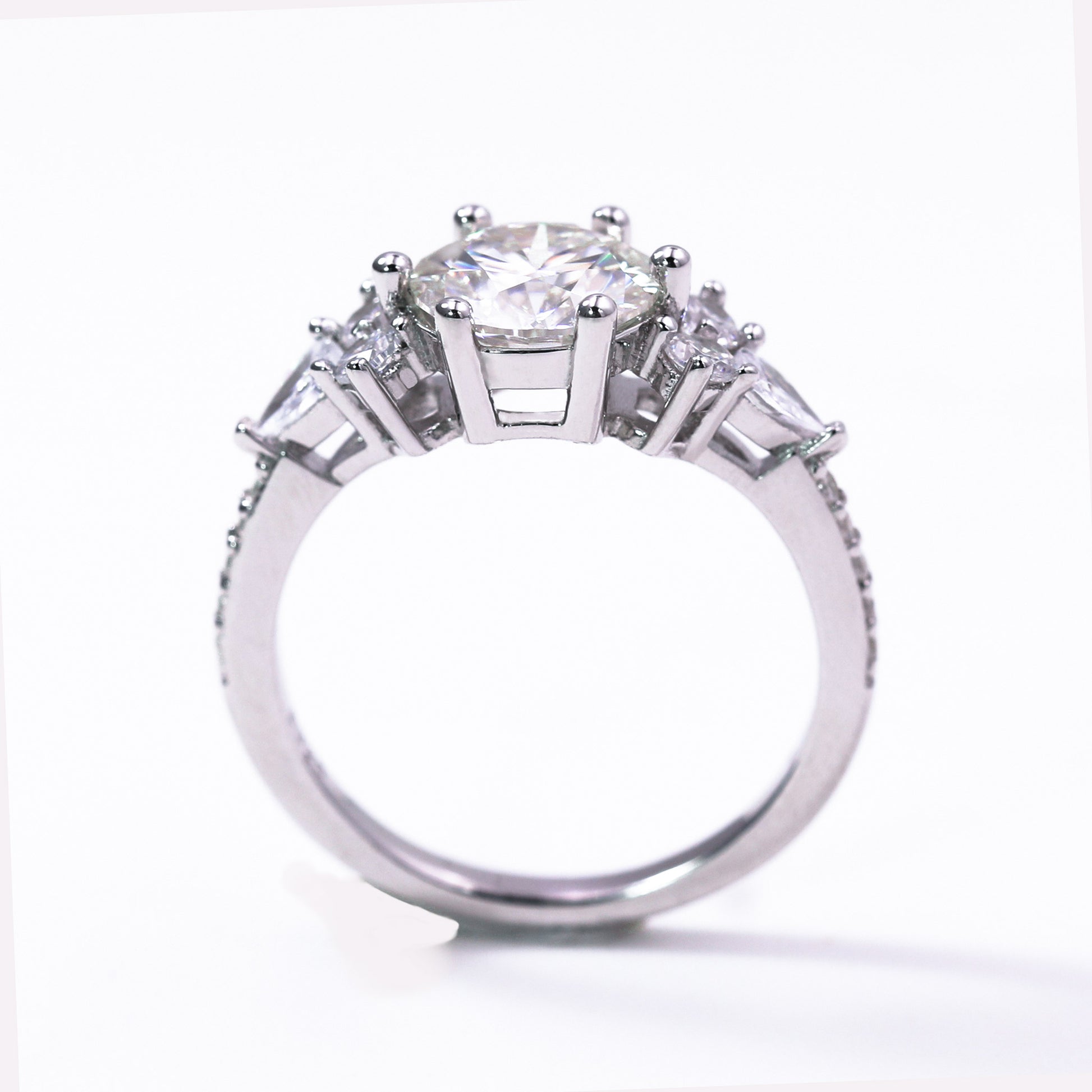Diamond ring with a central gemstone and three smaller stones on a white background