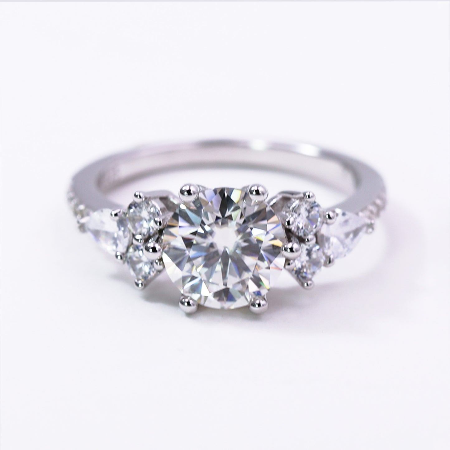 Diamond ring with three clear gemstones on a white background