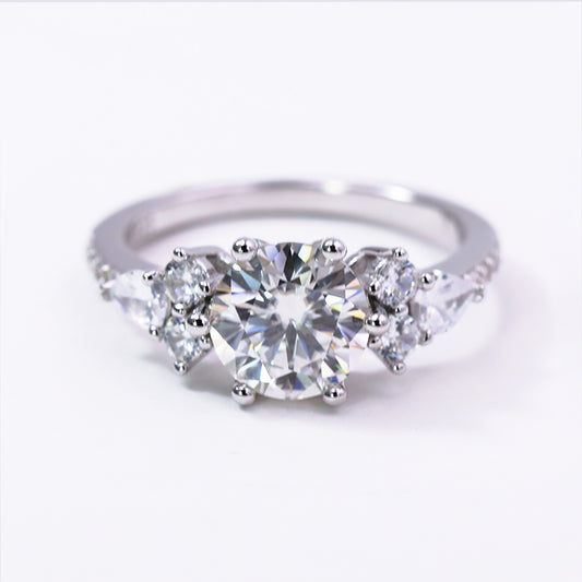 Diamond ring with three clear gemstones on a white background